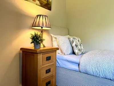 a lamp on a night stand next to a bed at Spacious 2 Bed-Flat in Glasgow City - Free Parking in Glasgow