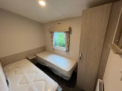 a small room with two beds and a window at Newton Stewart - Lodge - Sleeps 4 - Garden in Bargrennan