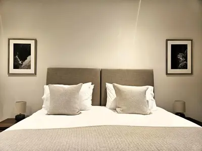 a bedroom with a large bed with white sheets and pillows at Edinburgh Elegant 1-Bedroom City Apartment in Edinburgh