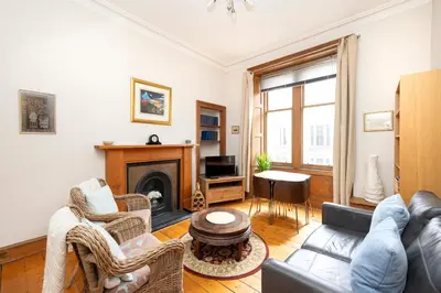a living room with a couch and a fireplace at Charming 1-Bedroom Edinburgh City Getaway in Edinburgh