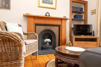 a living room with a fireplace and a tv at Charming 1-Bedroom Edinburgh City Getaway in Edinburgh