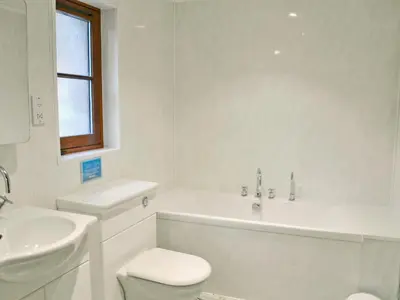 a white bathroom with a toilet and a sink at The Wheelhouse in Linlithgow