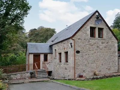 a stone building with a clock on the side of it at The Wheelhouse in Linlithgow
