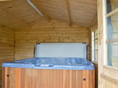 a large jacuzzi tub in a wooden cabin at Ashknowe Log Cabin - S4590 in Glenfarg