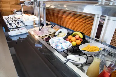 a buffet line with bowls of fruit and other food at Normandy Hotel (Near Glasgow Airport) in Paisley
