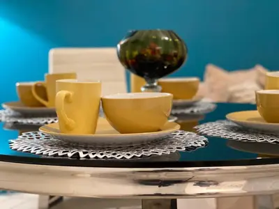 a table with yellow cups and saucers on it at HLA king court 3 in Motherwell