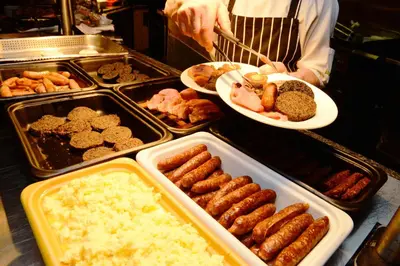 a person is preparing food in a buffet at Glynhill Hotel & Spa near Glasgow Airport in Paisley