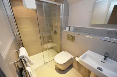 a bathroom with a shower and a toilet and a sink at Glynhill Hotel & Spa near Glasgow Airport in Paisley