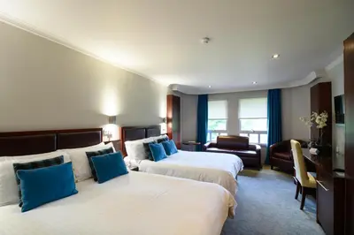 a hotel room with two beds with blue pillows at Glynhill Hotel & Spa near Glasgow Airport in Paisley