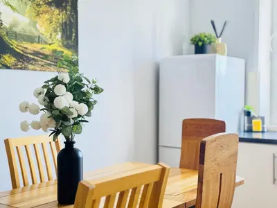 a dining room table with a vase of flowers on it at Skyline View Apartment in Edinburgh