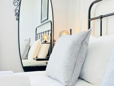 a bedroom with a white bed with a mirror at Skyline View Apartment in Edinburgh