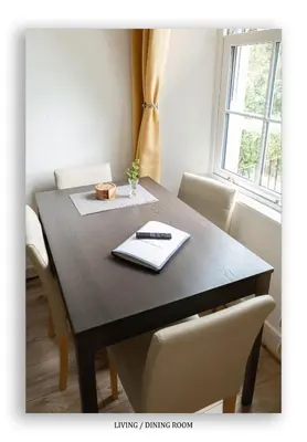 a dining room table with a laptop on it at Clarefoot Cottage in Moffat