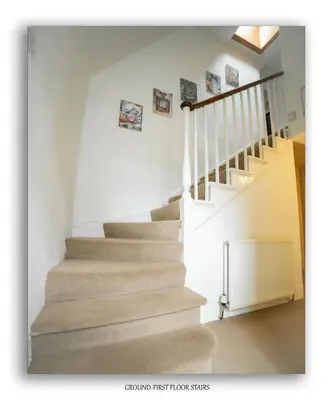 a staircase in a home with white walls at Clarefoot Cottage in Moffat