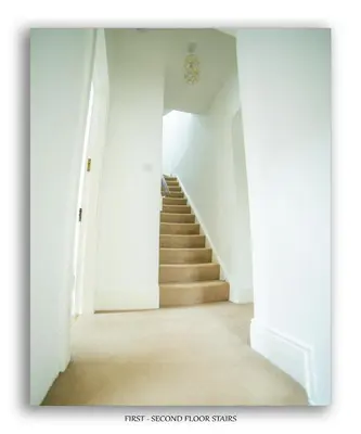 an empty hallway with stairs in a house at Clarefoot Cottage in Moffat