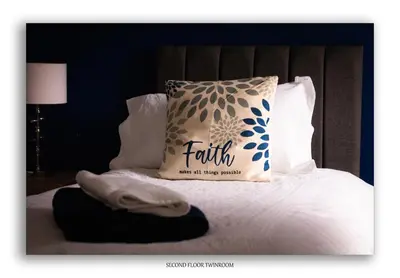 a pillow with the word faith is sitting on a bed at Clarefoot Cottage in Moffat