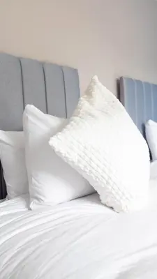a white pillow sitting on top of a bed at Campsie View in Glasgow