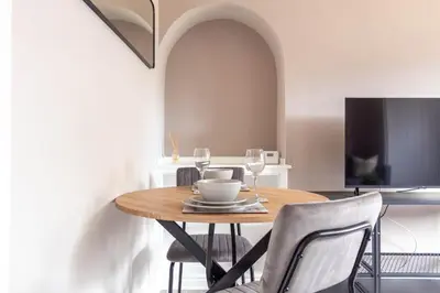 a dining room with a table with chairs and a tv at Campsie View in Glasgow