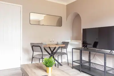 a dining room with a table and chairs and a mirror at Campsie View in Glasgow