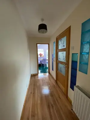 a room with a hallway with a table and a door at Stunning 3 bedroom house with 2 bathrooms in Mansewood