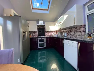 a kitchen with white appliances and a green floor at Stunning 3 bedroom house with 2 bathrooms in Mansewood