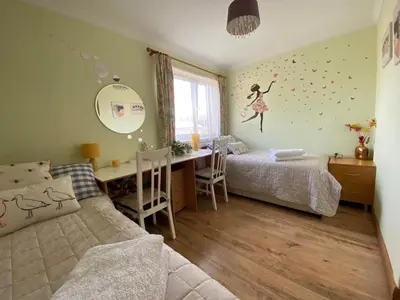 a bedroom with two beds and a desk in it at Stunning 3 bedroom house with 2 bathrooms in Mansewood