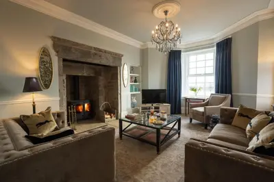 a living room with two couches and a fireplace at Milton House in Buchanty