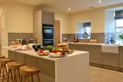 a kitchen with a table with fruits and vegetables on it at Milton House in Buchanty