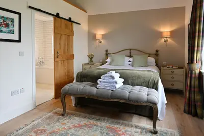 a bedroom with a bed and a bench with towels on it at The Old Farmhouse in Buchanty