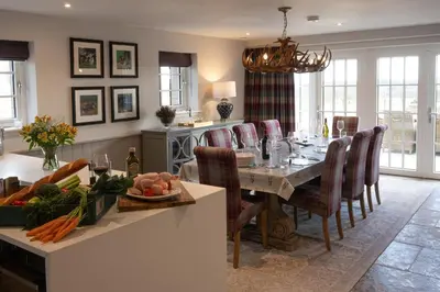 a dining room and kitchen with a table and chairs at The Old Farmhouse in Buchanty