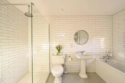 a white bathroom with a toilet and a sink at The Old Farmhouse in Buchanty