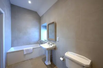 a bathroom with a sink and a toilet and a tub at Falcon Steading in Buchanty