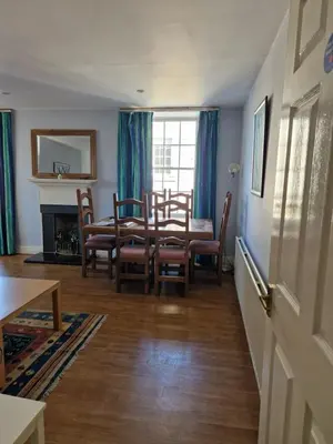 a dining room with a table and chairs and a fireplace at Rose Street 4 bedroom in Edinburgh