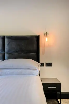 a bed with a black headboard and a side table at The Righ in Oban