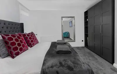 a bedroom with a large bed with red pillows and a mirror at The Bayview, Rothesay, Isle of Bute in Rothesay