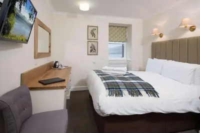 a hotel room with a bed and a desk and a television at The Inveraray Inn, BW Signature Collection in Inveraray