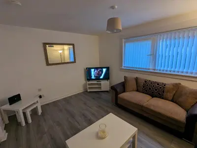 a living room with a couch and a tv at 4 bedroom Townhouse Greenock in Greenock