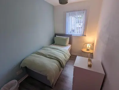 a small bedroom with a bed and a window at 4 bedroom Townhouse Greenock in Greenock