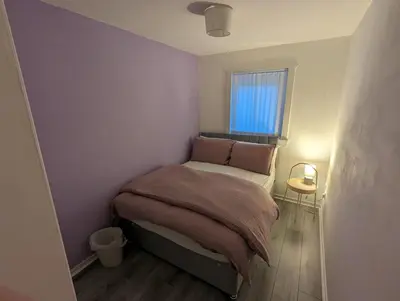 a small bedroom with a bed and a window at 4 bedroom Townhouse Greenock in Greenock