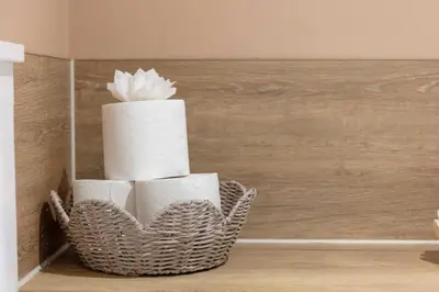 a basket filled with toilet paper on a wall at Wellington Lodge in Ayr