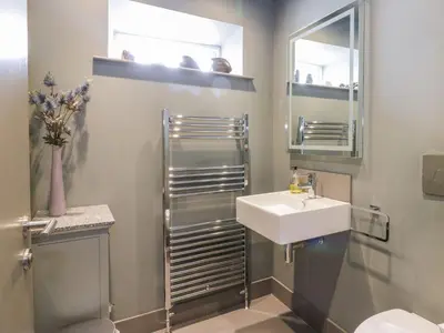 a bathroom with a sink and a toilet and a mirror at Wee Cottage in Moffat