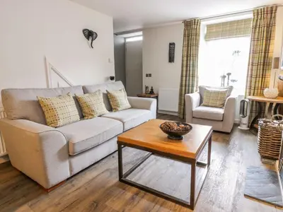 a living room with a couch and a coffee table at Wee Cottage in Moffat