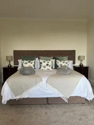 a bedroom with a bed with two pillows on it at The Farmhouse at Solsgirth Home Farm in Dollar