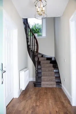 a staircase in a home with wood floors and a chandelier at The Farmhouse at Solsgirth Home Farm in Dollar