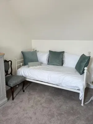 a white couch with green pillows in a living room at The Farmhouse at Solsgirth Home Farm in Dollar