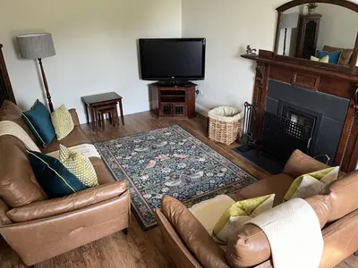 a living room with two couches and a fireplace at The Farmhouse at Solsgirth Home Farm in Dollar