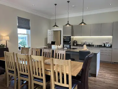 a kitchen and dining room with a table and chairs at The Farmhouse at Solsgirth Home Farm in Dollar
