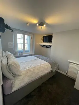 a bedroom with a large bed in a room at Blackbull With Rooms Lower in Cumbernauld