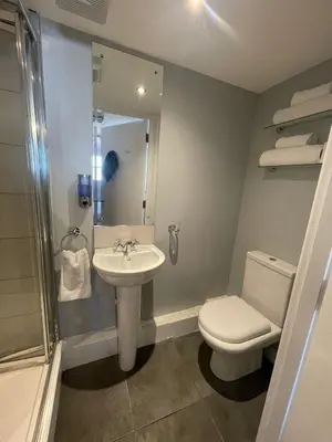 a bathroom with a toilet and a sink and a shower at Blackbull With Rooms Lower in Cumbernauld