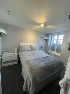 a bedroom with a large bed and a window at Blackbull With Rooms Lower in Cumbernauld