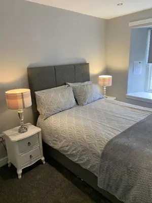 a bedroom with a bed with two lamps on a night stand at Blackbull With Rooms Lower in Cumbernauld